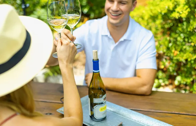 Couple Cheersing with Rombauer Chardonnay in a beautiful setting.